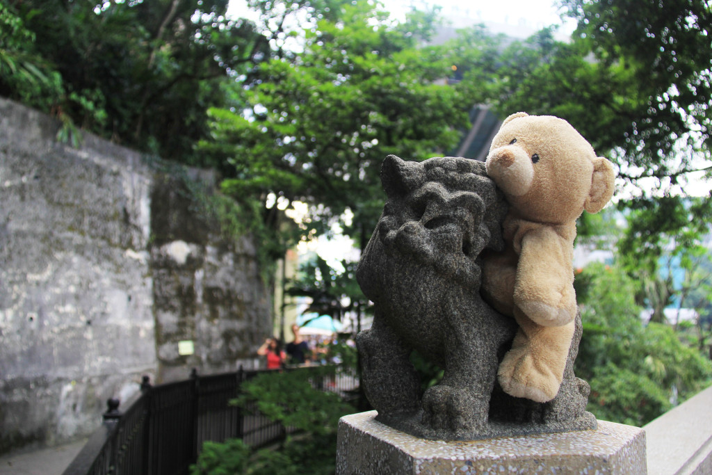 A stone lion on the side of a hiking path on Victoria Peak.