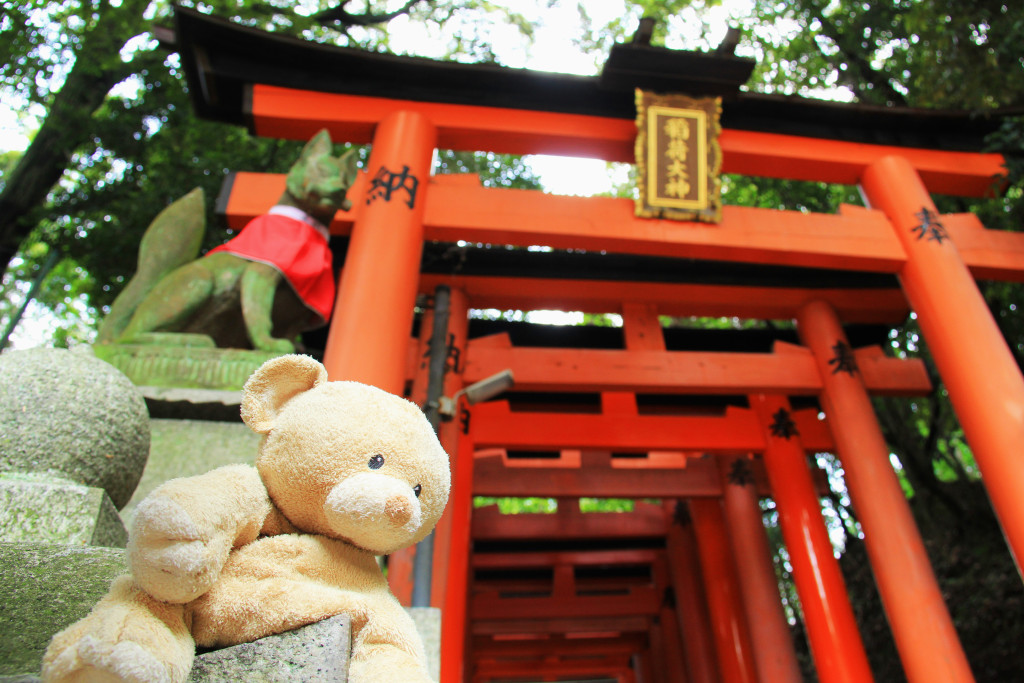 Beginning of a segment of torii gates, guarded by fox statues (and Woody).
