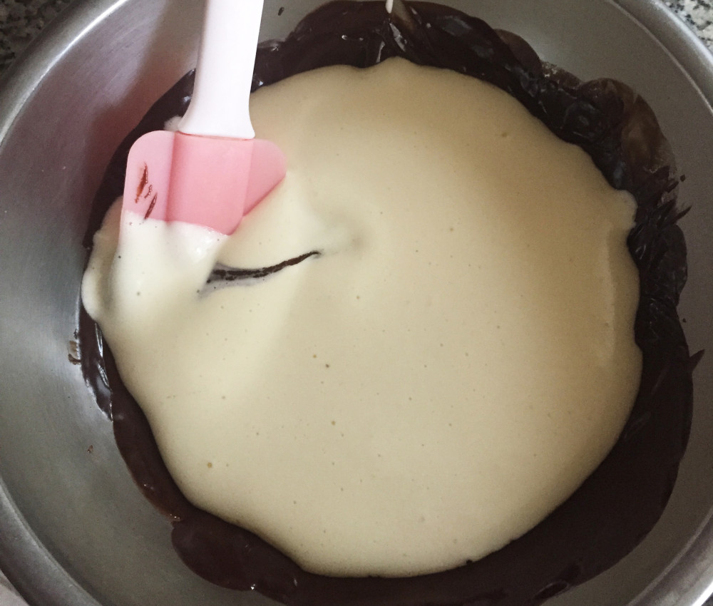 Folding 1/3 of the egg batter into the chocolate