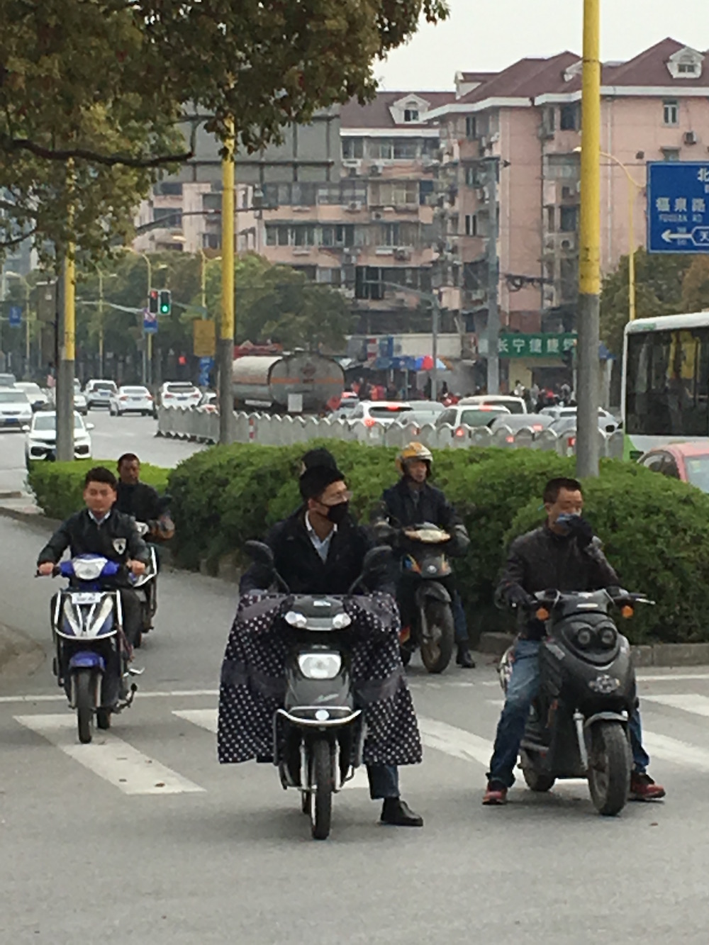 People wear these "oven mitt" outfits to protect themselves from the dirt while they ride their scooters to work. 